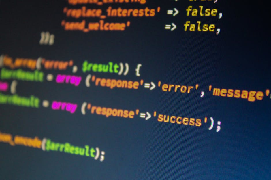 Image displaying a computer screen filled with lines of computer code written in various colors including yellow, blue, green, and purple on a dark background. The code appears to be markup or program